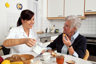 young lady assisting the senior woman on her meal