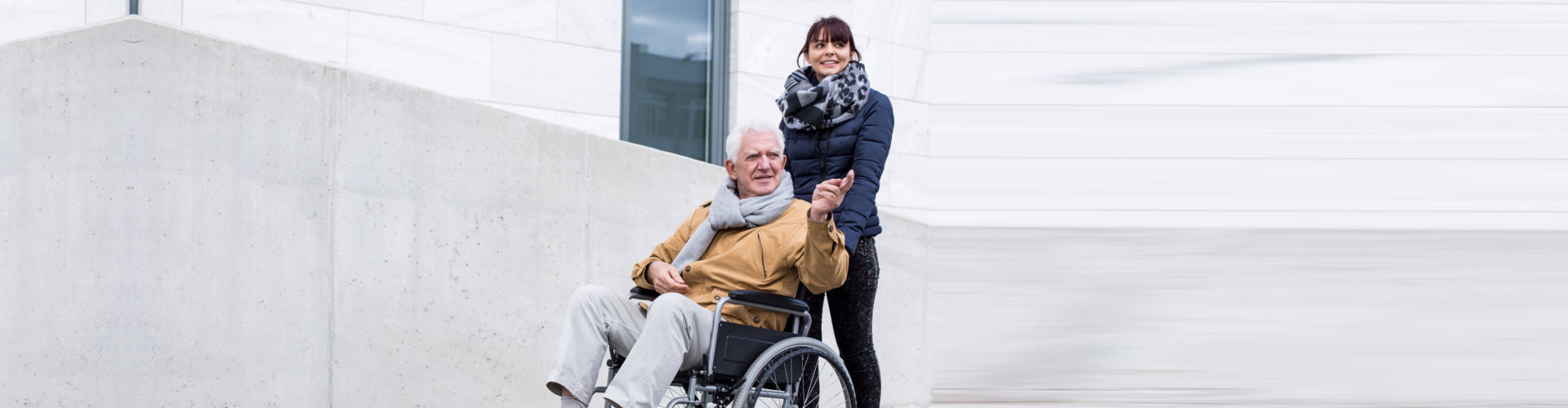 elderly man on wheelchair and staff smiling